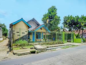 a house with a fence in front of a street at SPOT ON 2275 Omah Jm in Beran-kidul