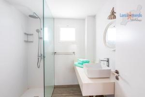 biała łazienka z umywalką i prysznicem w obiekcie Vivienda Vacacional Casa Las Cucharas w Costa Teguise +15 zdjęć