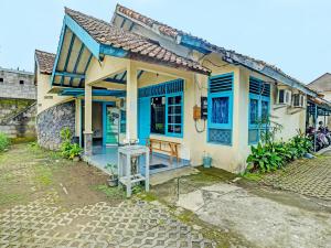 a small house with blue trim on a street at SPOT ON 2275 Omah Jm in Beran-kidul