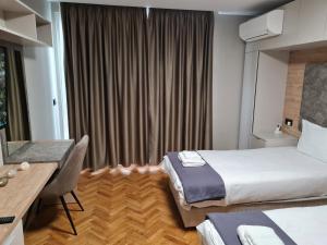 a hotel room with a bed and a desk at Чудесен нов апартамент Илинден in Varna City