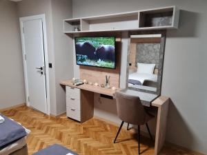 um quarto com uma secretária com um espelho e uma televisão em Чудесен нов апартамент Илинден em Varna City