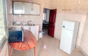 eine Küche mit einem Holztisch und einem Laptop darauf in der Unterkunft Résidences MAFCA in Conakry