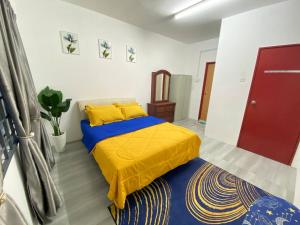 1 dormitorio con 1 cama con colcha amarilla en Homestay Kuala Terengganu Affan01 Dekat Pantai Batu Buruk en Kuala Terengganu