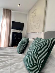 a bedroom with a bed with two pillows on it at Dimora Apartman in Debrecen