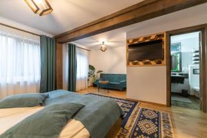 1 dormitorio con 1 cama y TV de pantalla plana en Ranger Chalet, en Moieciu de Sus