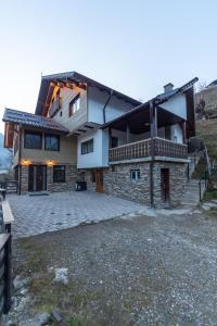 a house with a stone driveway in front of it at Ranger Chalet in Moieciu de Sus