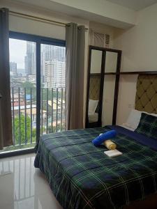 ein Schlafzimmer mit einem Bett und einem großen Fenster in der Unterkunft LOT 8 CONDOMINIUM 1BEDROOM MABOLO CEBU in Carreta