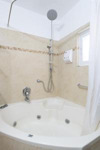 a white bath tub in a bathroom with a shower at Yagen boutique apartments in Haifa