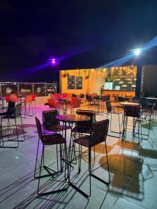 a group of chairs and tables in a patio at night at Hotel Wanderlust in Santa Marta