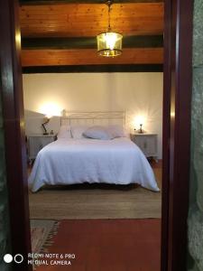 a bedroom with a white bed with two night stands at Casita en Domaio - Moaña in Moaña