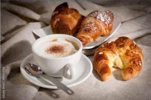 two plates of pastries and a cup of coffee and croissants at Suite SAN GENNARO in Naples