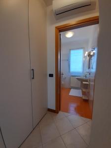a bathroom with a door leading to a sink at Casa di Clara in Portogruaro