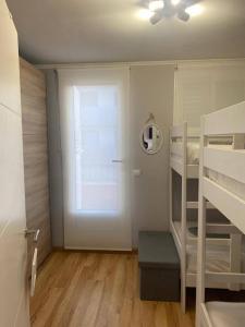 niewielka sypialnia z łóżkiem piętrowym i oknem w obiekcie Terrassa-Solarium Centre w mieście Platja  d'Aro