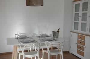 a white kitchen with a white table and chairs at RELAX Apartment mit Garten - Lifestyle am Bodensee, Fahrräder inklusive in Bregenz
