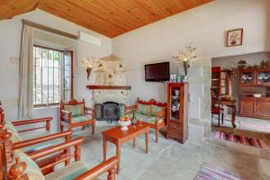 una sala de estar llena de muebles y una chimenea en Traditional Home Vereniki With Heated Pool - BY APOKORONAS VILLAS, en Gavalochori