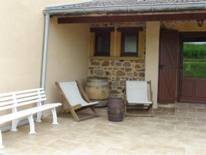 d'une terrasse avec 2 chaises blanches et un tonneau. dans l'établissement La maison du vigneron, à Ternand