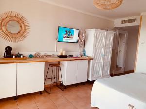 a kitchen with a desk and a bed in a room at STUDIO CARAMBOLE VUE MER - Piscines - Plages - Village vacances Sainte Anne Guadeloupe in Sainte-Anne