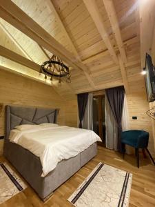 Chalet Montenegrina with jacuzzi في كولاسين: غرفة نوم بسرير كبير وسقف خشبي