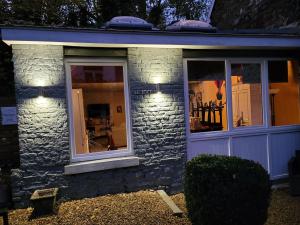 uma casa de pedra com duas janelas e luzes em le loft em Spa