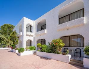 ein Gebäude mit Topfpflanzen davor in der Unterkunft Apartamentos Barbarroja - Formentera Break in Playa Migjorn