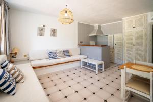 ein Wohnzimmer mit einem Sofa und einem Tisch in der Unterkunft Apartamentos Barbarroja - Formentera Break in Playa Migjorn