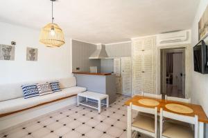 ein Wohnzimmer mit Sofa und Tisch in der Unterkunft Apartamentos Barbarroja - Formentera Break in Playa Migjorn + 30 Fotos