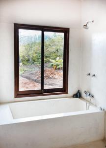 a bath tub in a bathroom with a window at Casa AMAR Piscinas Naturais in Lençóis