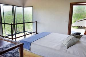 a bedroom with a bed and a large window at Casa AMAR Piscinas Naturais in Lençóis