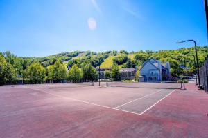 - un court de tennis avec une personne debout dans l'établissement Hillside BLUE MTN Family Loft @ North Creek Resort, à Blue Mountains