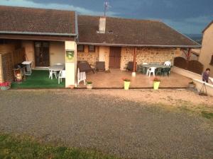 a house with a patio with a table and chairs at La maison du vigneron in Ternand