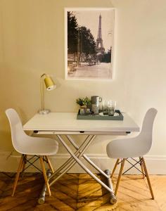 einen Schreibtisch mit 2 Stühlen und einen Tisch mit einer Lampe in der Unterkunft Pompidou ROOM PARIS CENTRE in Paris