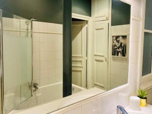 y baño con bañera, lavabo y espejo. en Pompidou ROOM PARIS CENTRE en París