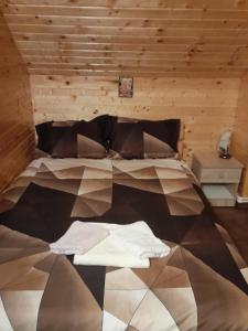 um quarto com uma cama e uma parede de madeira em Casa Sebastian - Rau Mare Retezat 