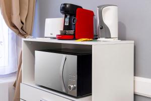 a table with a microwave and a coffee maker on it at LD-Location Hôtel in Montluçon