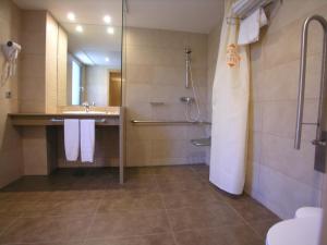 un bagno con doccia, lavandino e specchio di Espel ad Andorra la Vella