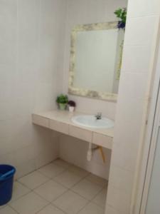 ein weißes Badezimmer mit einem Waschbecken und einem Spiegel in der Unterkunft Seaview Pd homestay Apartment in Port Dickson