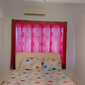 Bett in einem Zimmer mit rosa Fenster in der Unterkunft Seaview Pd homestay Apartment in Port Dickson