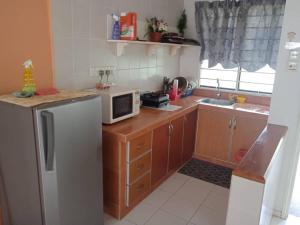 eine kleine Küche mit einem Kühlschrank und einer Mikrowelle in der Unterkunft Seaview Pd homestay Apartment in Port Dickson