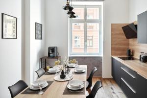 une salle à manger avec une table et des chaises ainsi qu'une cuisine dans l'établissement Stylish Apartment in Smíchov by Prague Days, à Prague