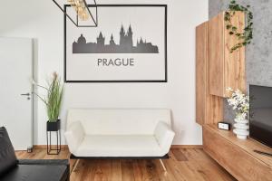 sala de estar con sofá blanco y una foto en la pared en Stylish Apartment in Smíchov by Prague Days, en Praga