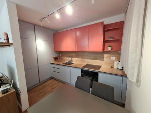 eine kleine Küche mit roten Schränken und einem Waschbecken in der Unterkunft Rita Apartment in Gjakove