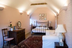 ein Schlafzimmer mit einem Bett und einem Tisch mit einer Lampe in der Unterkunft Stylish bolthole in the heart of the Meon Valley in East Meon