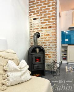 a black stove in a room with a brick wall at TINY CABIN in Braşov