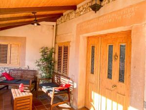 eine Veranda mit zwei Bänken an einem Haus in der Unterkunft Villa Lucia in Castroserna de Abajo