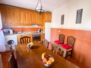 una cocina con una mesa con un bol de fruta. en Villa Lucia, en Castroserna de Abajo