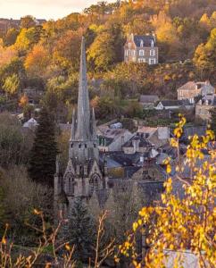 an old building with a steeple in a town at Profitez d'une douce nuit avec jacuzzi in Fougères