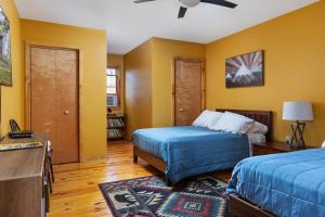 een slaapkamer met 2 bedden en gele muren bij Sleepy Hollow 5BR Cabin - National Park 7 Min, Hot Tub, Fire Pit, Sleeps 12 in Luray