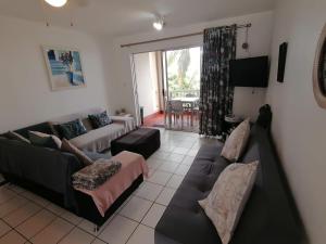 a living room with a couch and a table at 125 Laguna La Crete, Uvongo in Margate