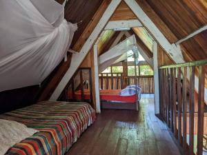 a bedroom in a log cabin with a bed at Les Acacias Bungalows in Manambato