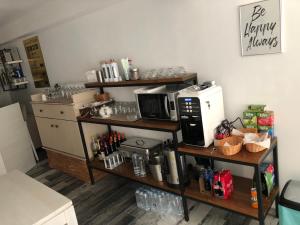a kitchen with a shelf with a microwave and a coffee maker at Vila LOFT CUBE in Sinaia